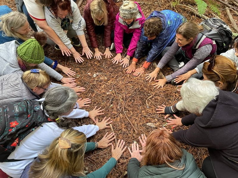 Retreat group in a circle with their hands on the ground pointed into the circle